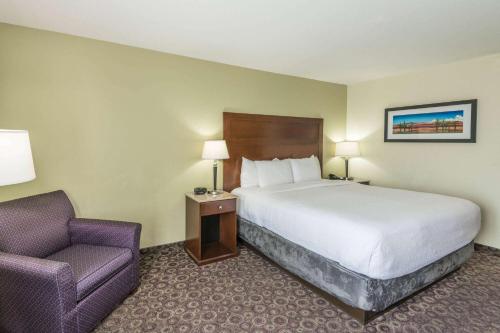 a hotel room with a bed and a chair at La Quinta by Wyndham Las Vegas Airport South in Las Vegas