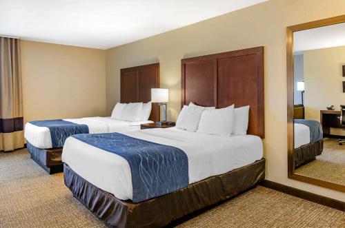 a hotel room with two beds and a mirror at Comfort Inn Bozeman near University in Bozeman