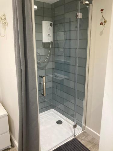 a shower with a glass door in a bathroom at Brand new apartment in Knutsford in Knutsford