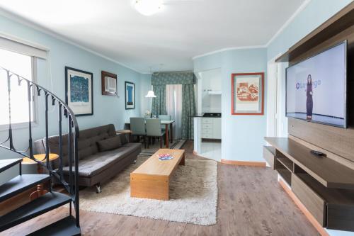 a living room with a couch and a tv at Paulista Flat in Sao Paulo