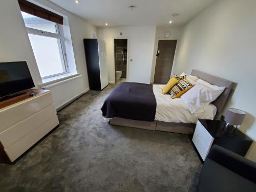 a bedroom with a bed and a flat screen tv at The Ashcroft Apartments Free Parking in Manchester