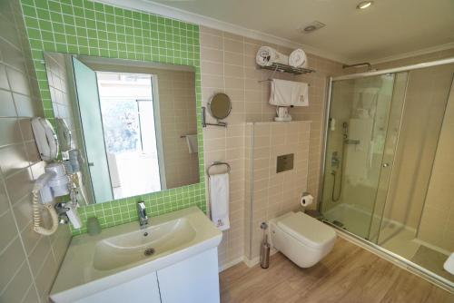 a bathroom with a toilet, sink and tub at Orka Boutique Hotel in Fethiye