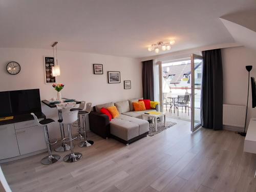 a living room with a couch and a table at Apartamenty Asis in Darłówko