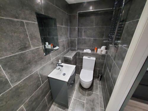 a bathroom with a toilet and a sink at The Ashcroft Apartments Free Parking in Manchester