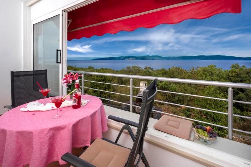 una mesa y sillas en un balcón con vistas al océano en B Apartment, en Ravni