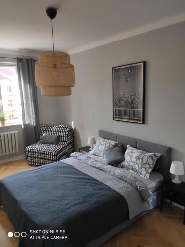 1 dormitorio con 1 cama y 1 silla en Apartament przy Zamku, en Lublin