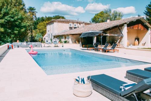 una piscina con sedie e una casa di Le Bon Ami a Fronsac