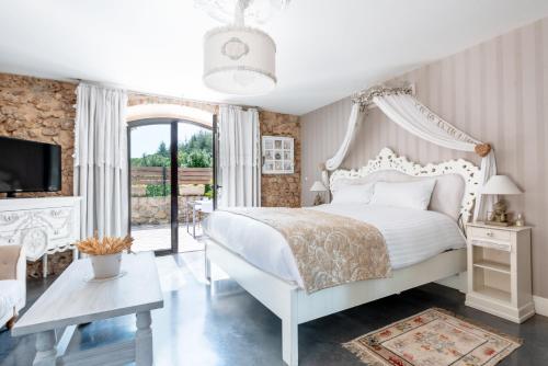 a bedroom with a white bed and a large window at Le Tr&eacute;sor des Templiers in Malataverne