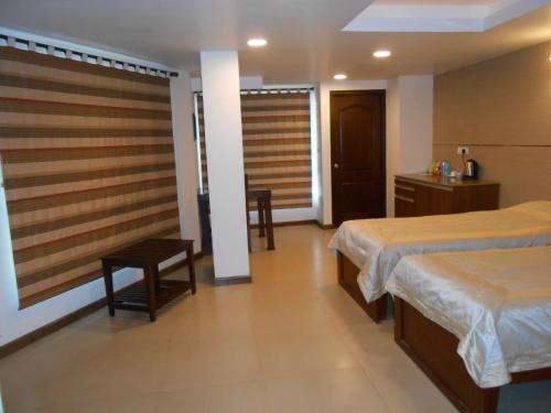 a hotel room with two beds and a table at Brunton Heights Executive Suites in Bangalore