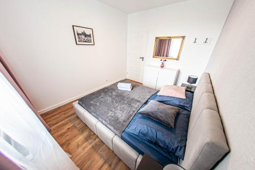 a bedroom with a bed and a couch in it at Euro Apartments New Gardens Delux in Gdańsk