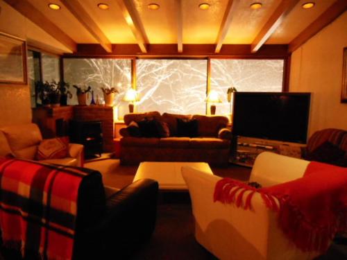 a living room with couches and a flat screen tv at Tsubame Highland Lodge燕ハイランドロッジ in Myoko