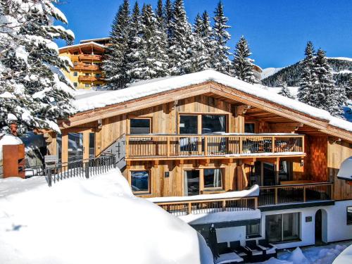 a log cabin in the snow with trees at Enzian Wohnung H in Königsleiten