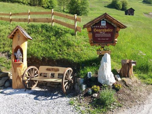 a wooden cart and a sign in a field at Gästehaus Hagenhofer in Dorfgastein