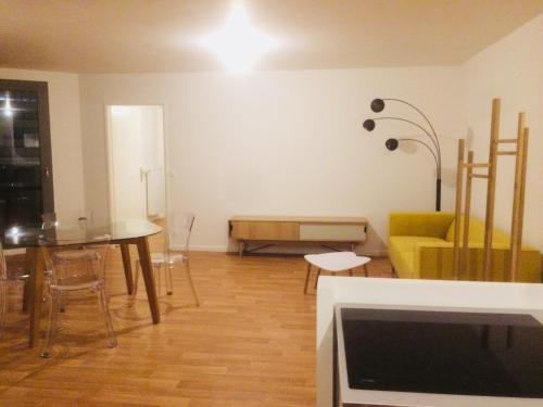 聖但尼的住宿－Majestics Luxury Apartments - 3BR With private Parking in front of train station - Paris Stade de France RER B，客厅配有桌子和黄色沙发