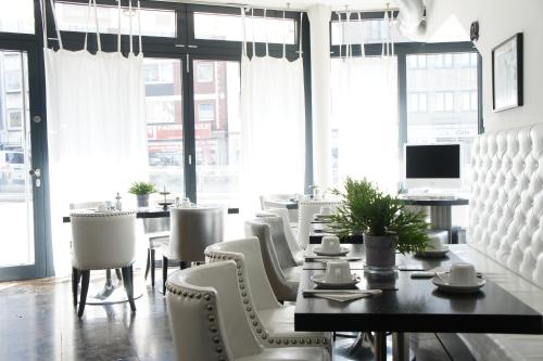 a dining room with a table and chairs and windows at Business Wieland Hotel in Düsseldorf