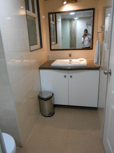 a bathroom with a white sink and a mirror at Brunton Heights Executive Suites in Bengaluru