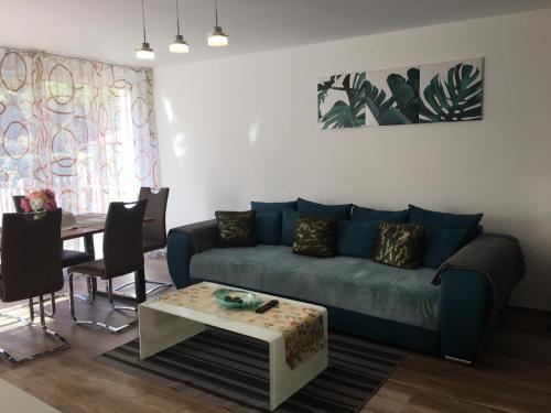 a living room with a blue couch and a table at Ferienwohnungen Weiherhausstraße 6 in Herten