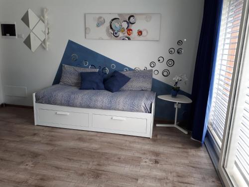 a bedroom with a white bed with a blue headboard at "CASABANA" - relax tutto l'anno - giardino - piscina Top in Malcesine