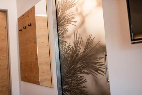 a glass door with a plant on the wall at Unterlutaschg-Chalet Appartement am Hof in Slingia
