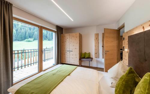 a bedroom with a bed and a large window at Unterlutaschg-Chalet Appartement am Hof in Slingia