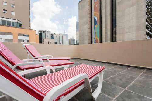 een rij ligstoelen op een dak bij Paulista Flat in Sao Paulo