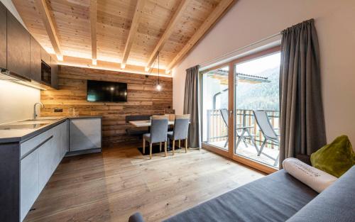 a room with a kitchen and a table with chairs at Unterlutaschg-Chalet Appartement am Hof in Slingia