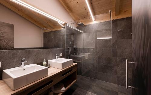a bathroom with two sinks and a shower at Unterlutaschg-Chalet Appartement am Hof in Slingia