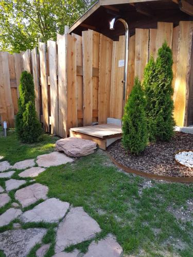 a garden with a bench in front of a wooden fence at AGRITURISMO La Giasena in Ponte nellʼAlpi