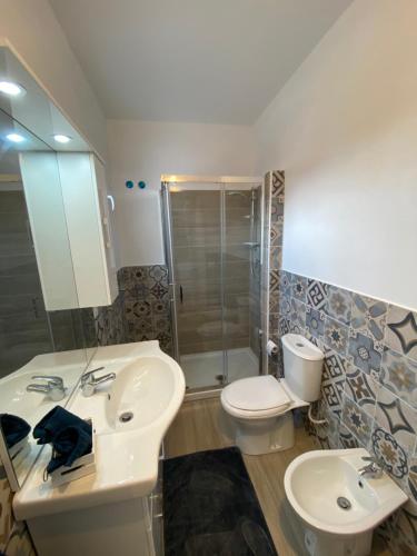 ein Badezimmer mit einem Waschbecken, einem WC und einem Spiegel in der Unterkunft HOME CITY in Castellammare del Golfo