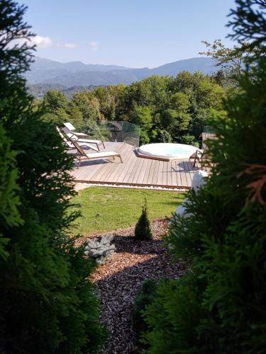 a backyard with a deck and a swimming pool at AGRITURISMO La Giasena in Ponte nellʼAlpi