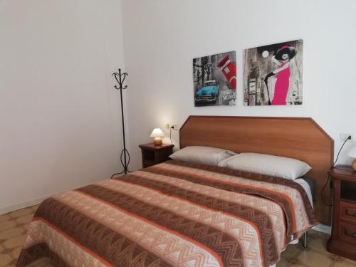 sypialnia z łóżkiem i zdjęciem na ścianie w obiekcie Appartamento: tranquillità o divertimento w Bolonii