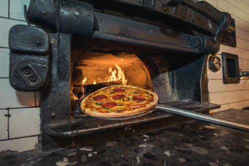 a pizza is being cooked in an oven at Hotel Brienzerburli in Brienz