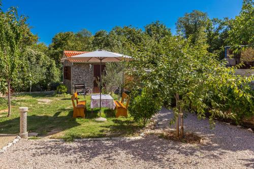 a house with an umbrella and a table and chairs at Holiday Home Vrh in Vrh