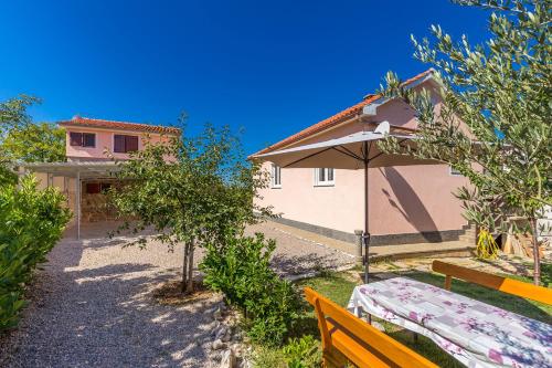 a table and an umbrella in front of a house at Holiday Home Vrh in Vrh