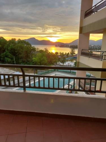 a balcony of a building with a sunset in the background at Marina Heights Seaview Resort 2 in Lumut