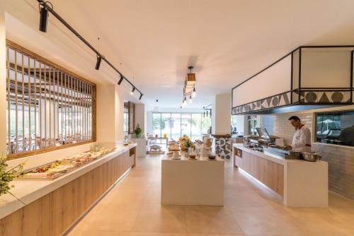 a restaurant with a man standing in the kitchen at Matala Bay Hotel in Matala