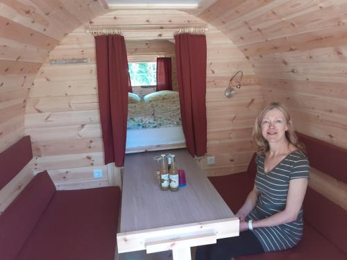 a woman sitting at a table in a tiny house at Fuchsbau in Walsrode