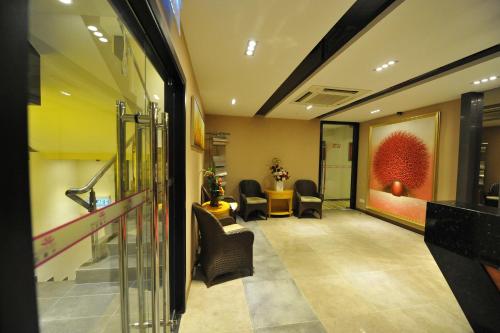a waiting room with chairs and a painting on the wall at Milano Hotel in Kluang