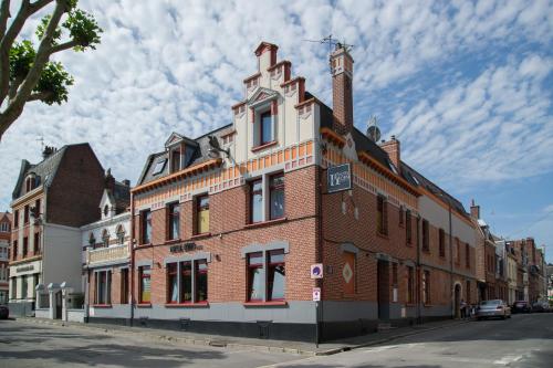 ein großes Backsteingebäude an der Straßenseite in der Unterkunft Hotel Eden in Béthune