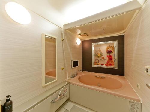 a bathroom with a tub and a sink at Hotel Fine Rokko Kita Ichibanchi in Kobe