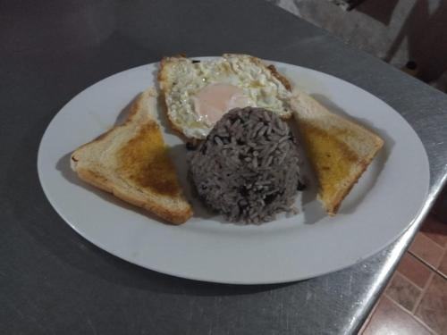 a plate of food with an egg and two pieces of toast at Posada Rio Celeste in in San Rafael