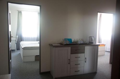 a room with a counter and a bed and a mirror at Penzion 68 in Kladno