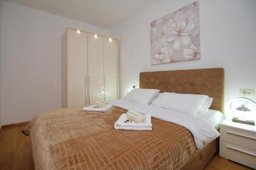 ein Schlafzimmer mit einem Bett mit zwei Handtüchern darauf in der Unterkunft Vila Pekovic green-Apartman PAMA in Zlatibor