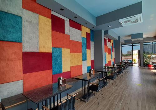 un ristorante con una parete colorata, tavoli e sedie di Luna Mare Resort Mersin a Mersin