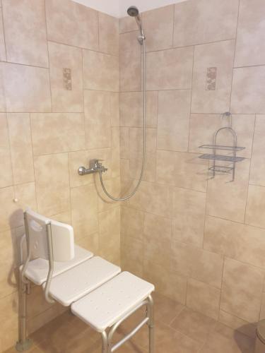 a shower with a bench and a shower head in a bathroom at Traditional Guesthouse Marousio in Rodavgi