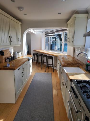 una cucina con armadietti bianchi e pavimenti in legno di SunnyVale a Barry