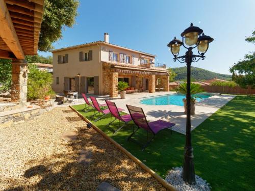 une maison avec des chaises de pelouse violettes et un pôle lumineux dans l'établissement Villa de charme avec piscine chauffée, Jacuzzi et Sauna, à Taradeau