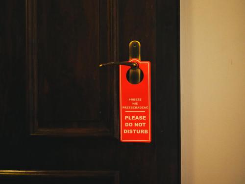 a red sign on a door that says please do not disturb at Legnicki Browar Książęcy Hotel i Restauracja in Legnica