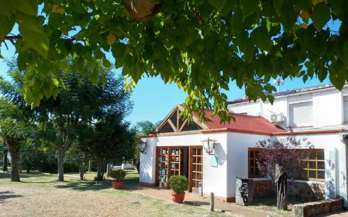 a white building with a red roof at Hotel La Posta del Dayman in Termas del Daymán