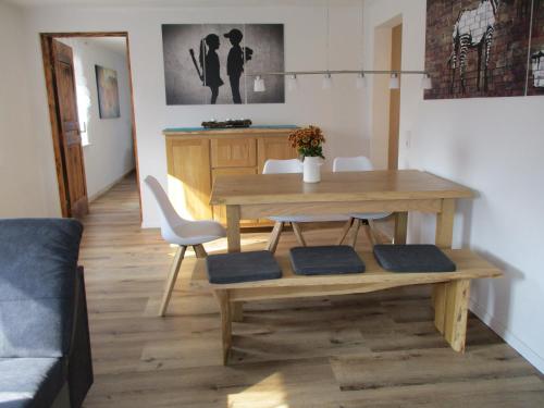 een woonkamer met een houten tafel en stoelen bij Ferienwohnung Rösch in Feuchtwangen